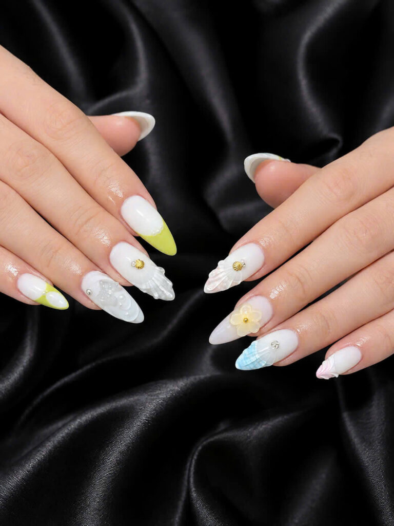White almond nails with pastel tips, floral accents and shell details